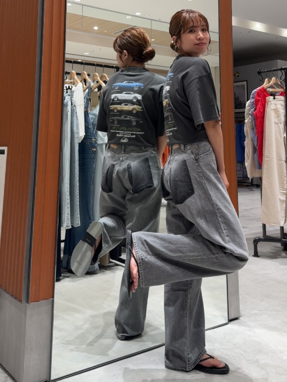 ブラック系のデニムパンツ、グレー系のTシャツ/カットソー、ブラック系のサンダルを着用したレディースの夏コーディネートの7枚目の写真