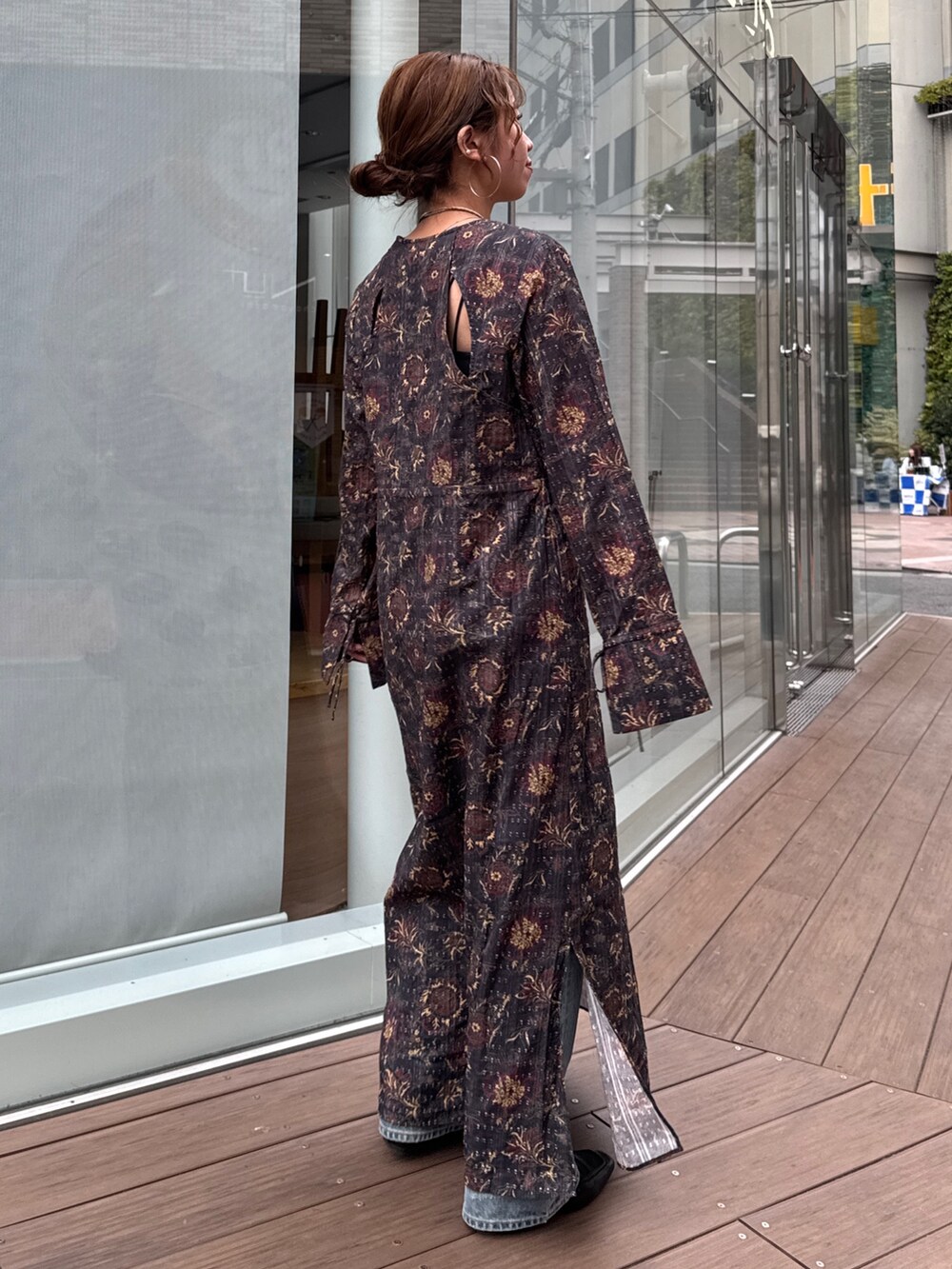 ブラック系のワンピース、ブルー系のデニムパンツ、ブラウン系のネックレスを着用したレディースの冬コーディネートの3枚目の写真