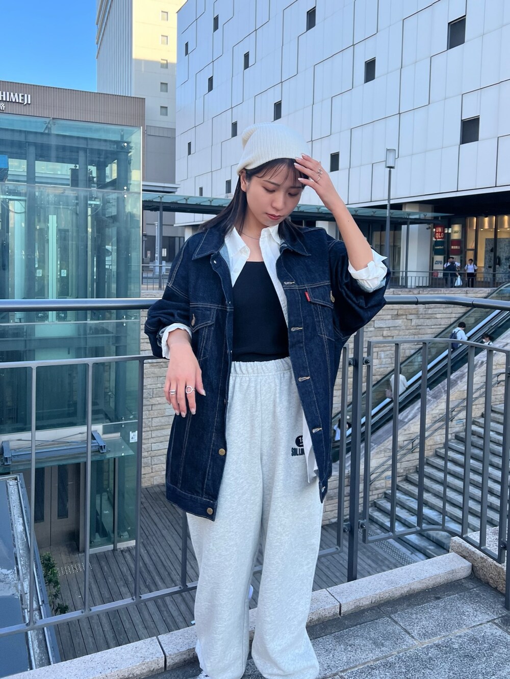 グレー系のスウェットパンツ、ブルー系のデニムジャケット、ブラック系のキャミソールを着用したレディースの秋コーディネートの7枚目の写真