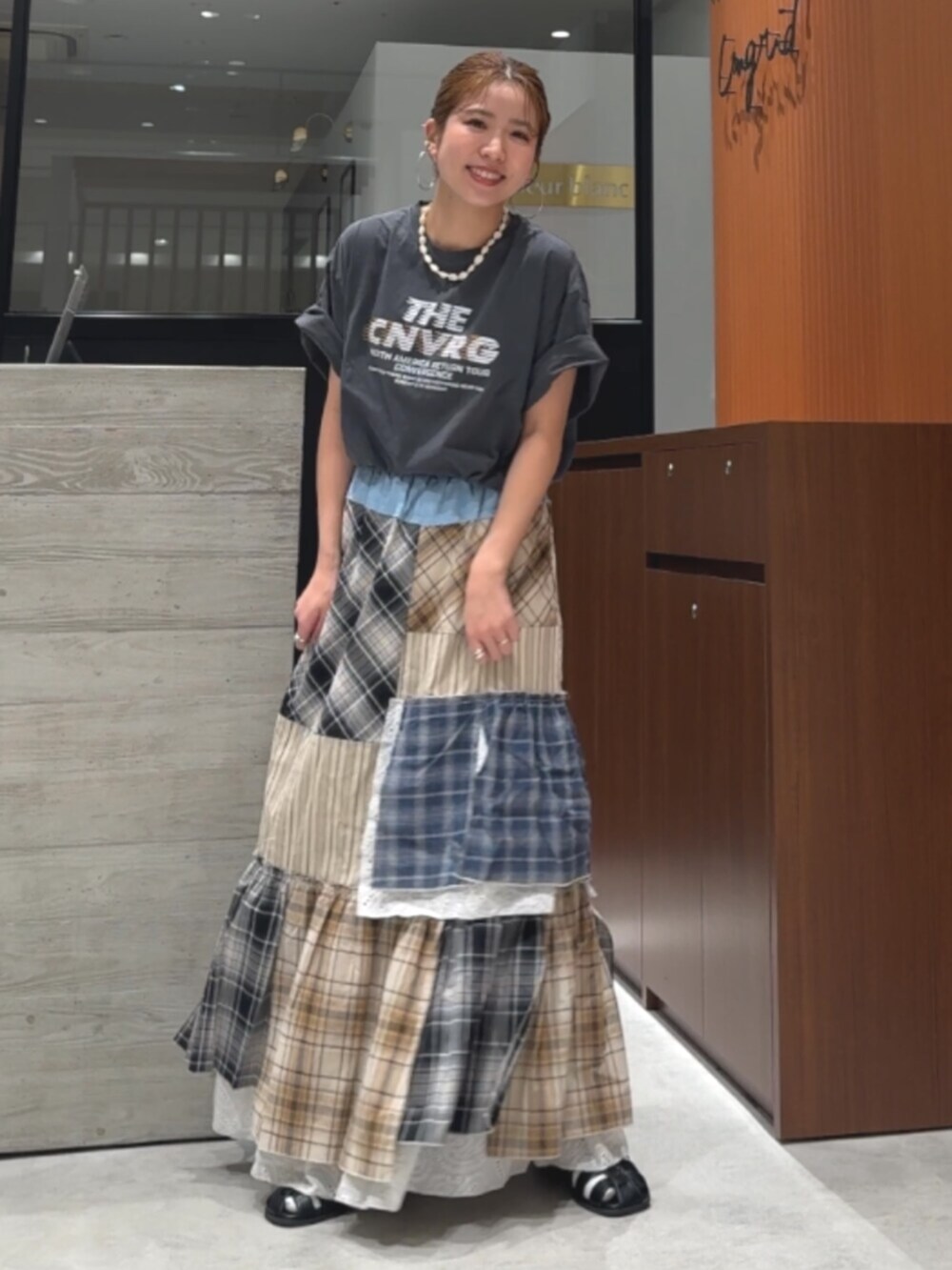 グレー系のTシャツ/カットソー、ブラック系のサンダル、その他のスカートを着用したレディースの春コーディネートの2枚目の写真