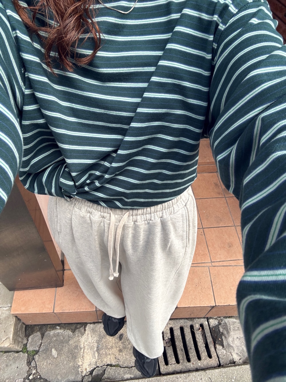 ホワイト系のスウェットパンツ、グリーン系のTシャツ/カットソーを着用したレディースの冬コーディネートの9枚目の写真