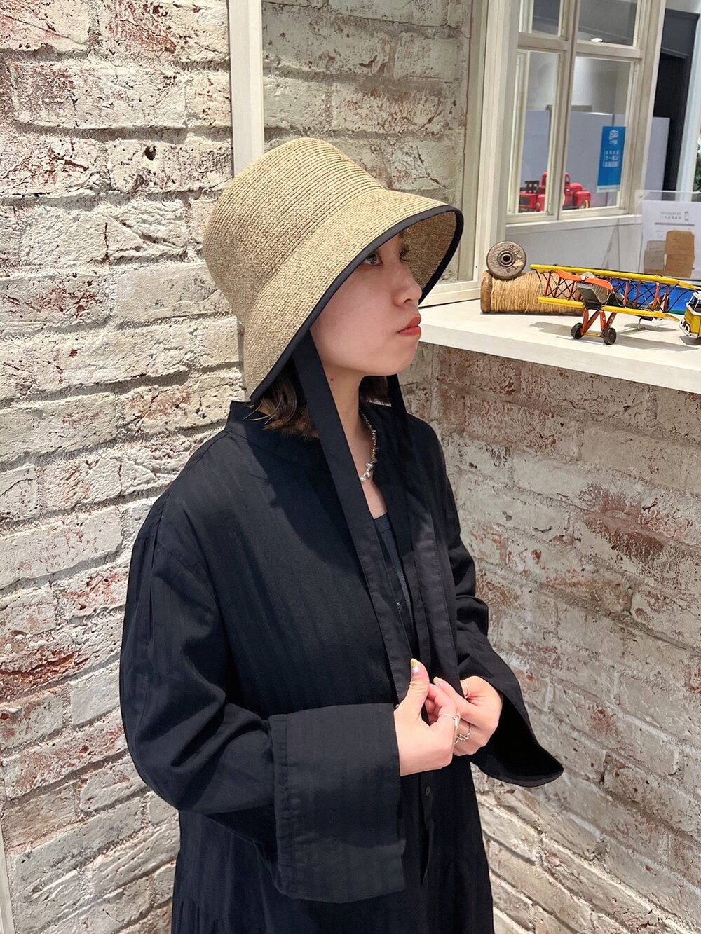 ブルー系のデニムパンツ、ブラック系のサンダル、ブラック系のワンピースを着用したレディースの春コーディネートの8枚目の写真