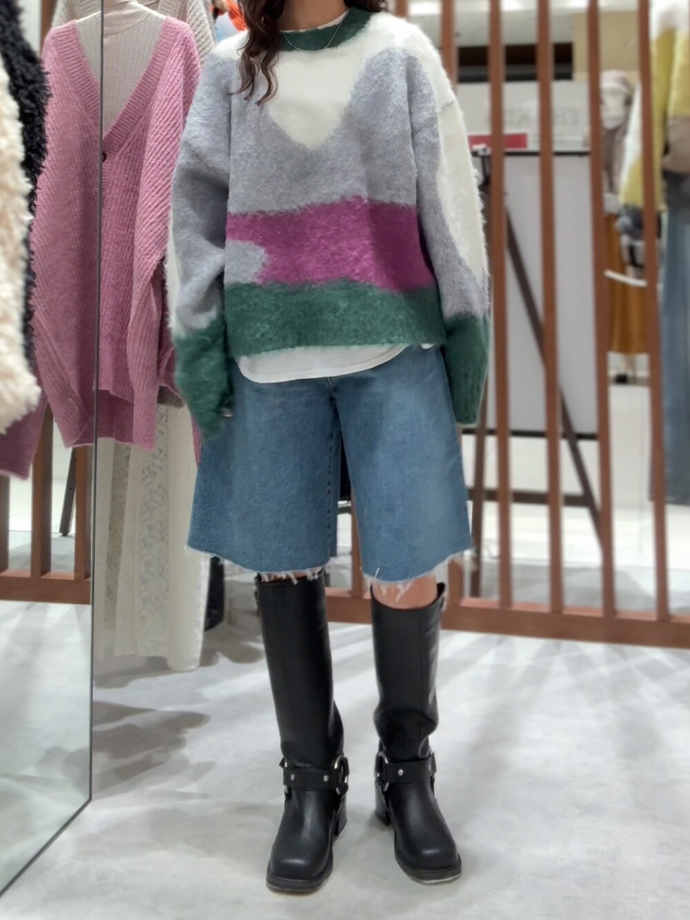 グリーン系のニット/セーター、ホワイト系のTシャツ/カットソー、ブルー系のデニムパンツを着用したレディースの秋コーディネートの4枚目の写真