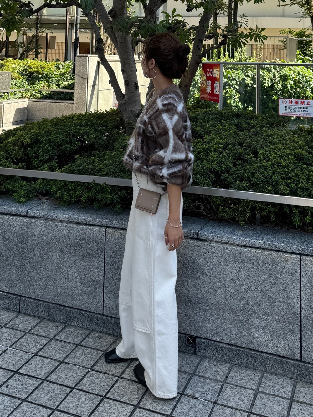 ブラウン系のニット/セーター、ホワイト系のデニムパンツを着用したレディースの秋コーディネートの9枚目の写真