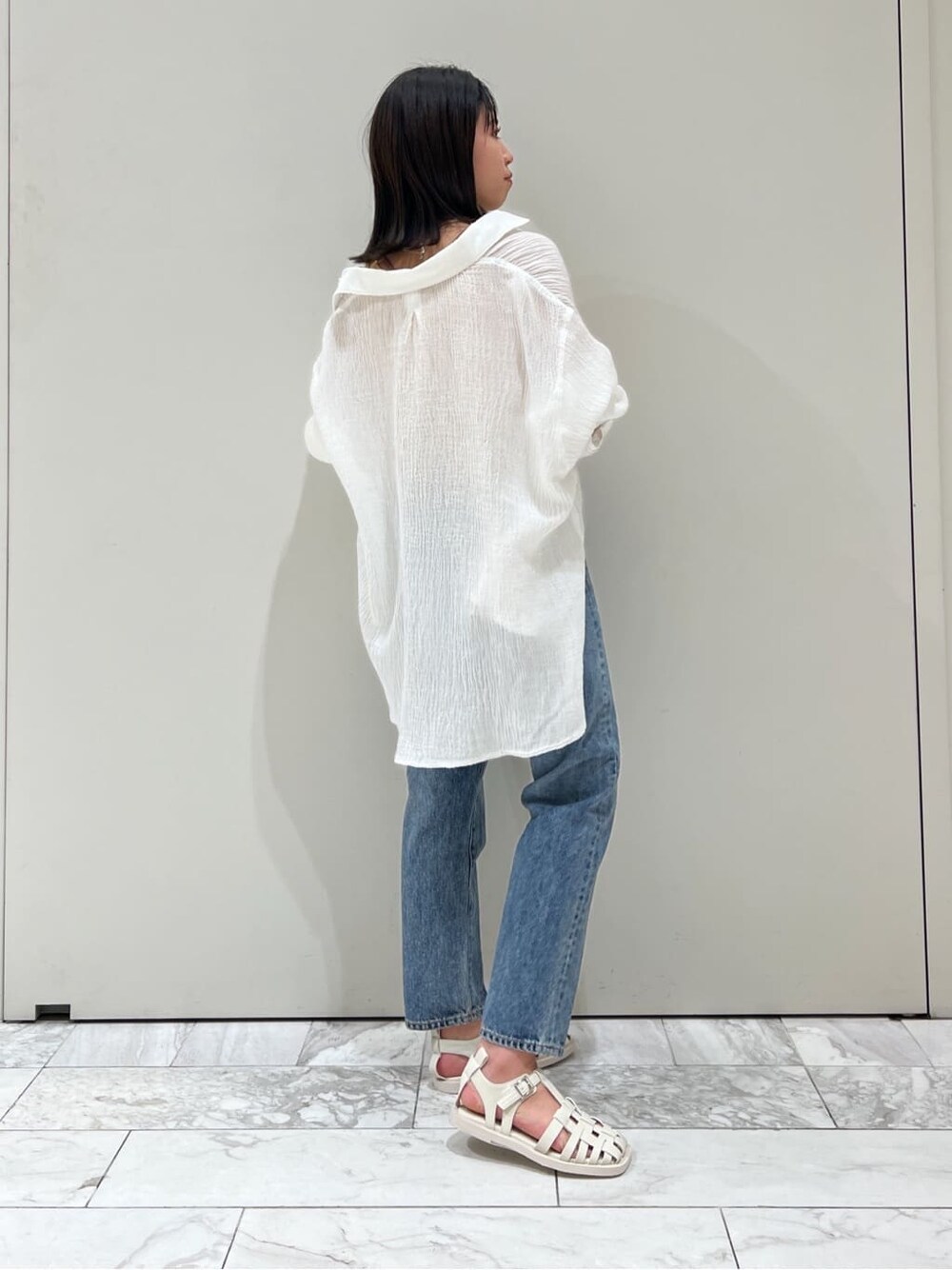 ブルー系のデニムパンツ、オレンジ系のタンクトップ、ホワイト系のシャツ/ブラウスを着用したレディースの春コーディネートの4枚目の写真