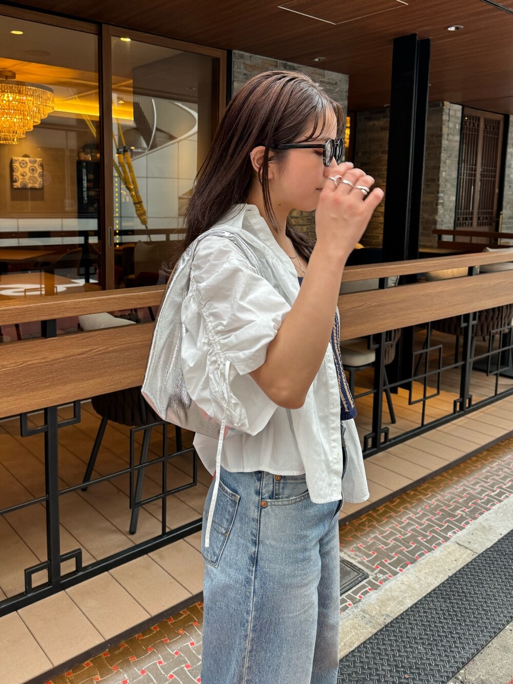 ブルー系のデニムパンツ、ホワイト系のシャツ/ブラウス、シルバー系のハンドバッグを着用したレディースの春コーディネートの8枚目の写真