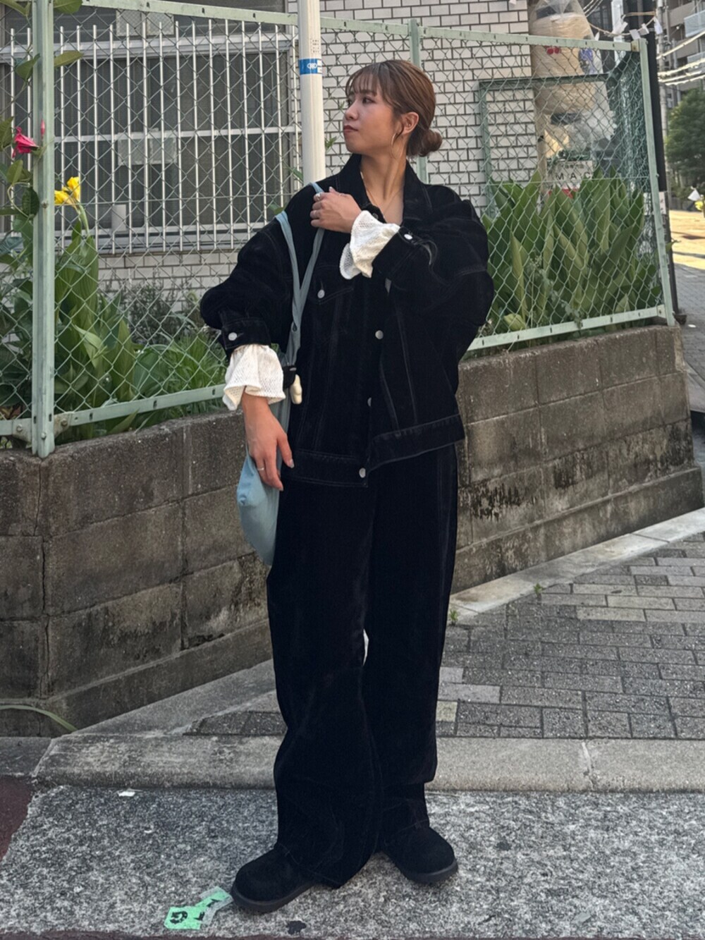 ブラック系のスリッポン、ブラック系のデニムパンツ、ブルー系のトートバッグを着用したレディースの夏コーディネートの3枚目の写真