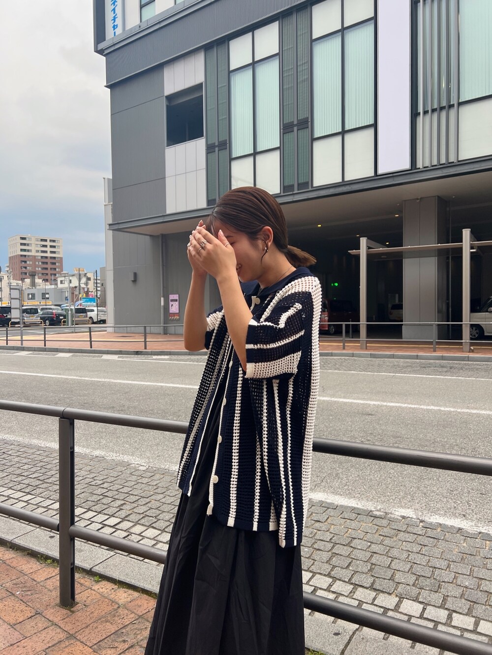 ブラック系のワンピース、ブルー系のカーディガン/ボレロ、ブラック系のサンダルを着用したレディースの春コーディネートの7枚目の写真