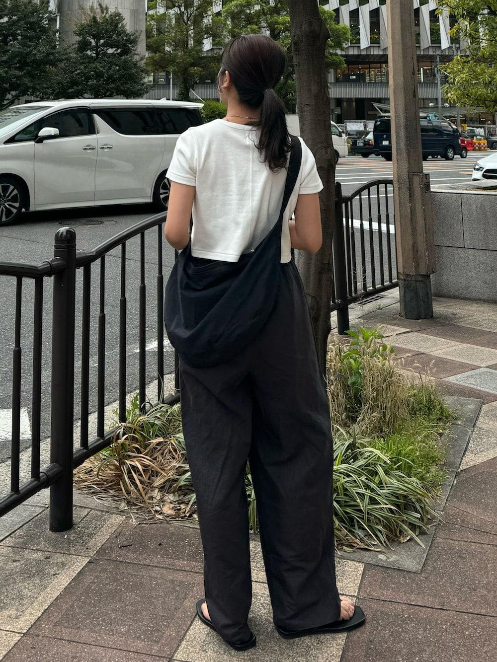 ホワイト系のTシャツ/カットソー、グレー系のその他パンツ、ブラック系のサンダルを着用したレディースの春コーディネートの6枚目の写真