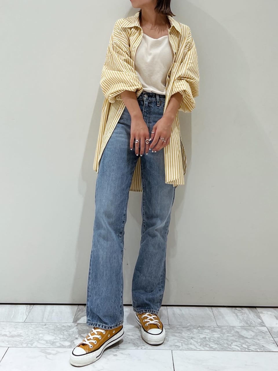 ホワイト系のキャミソール、ブルー系のデニムパンツ、イエロー系のシャツ/ブラウスを着用したレディースの夏コーディネートの2枚目の写真