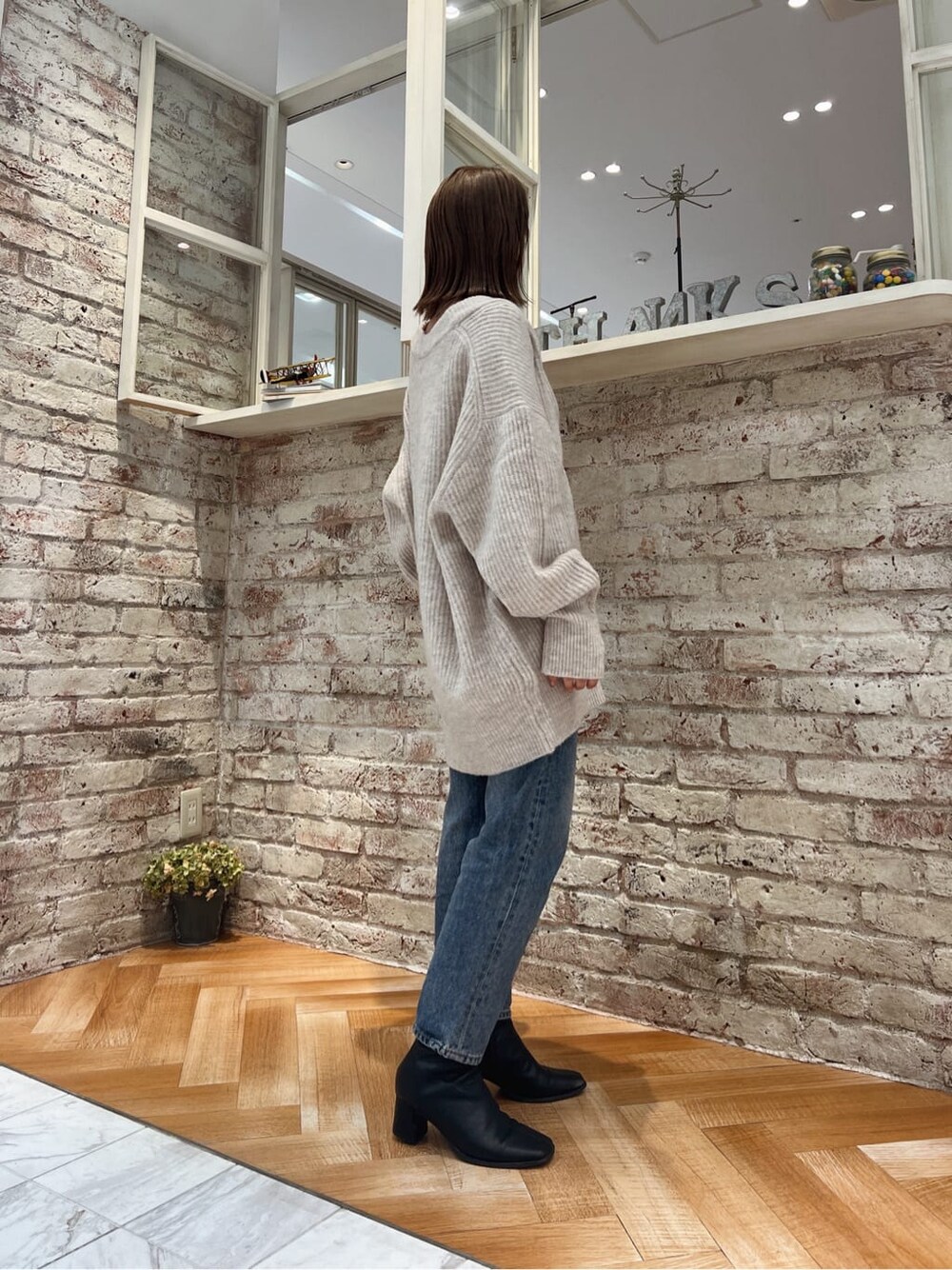 ブラック系のブーツ、ブルー系のデニムパンツ、ホワイト系のカーディガン/ボレロを着用したレディースの秋コーディネートの9枚目の写真