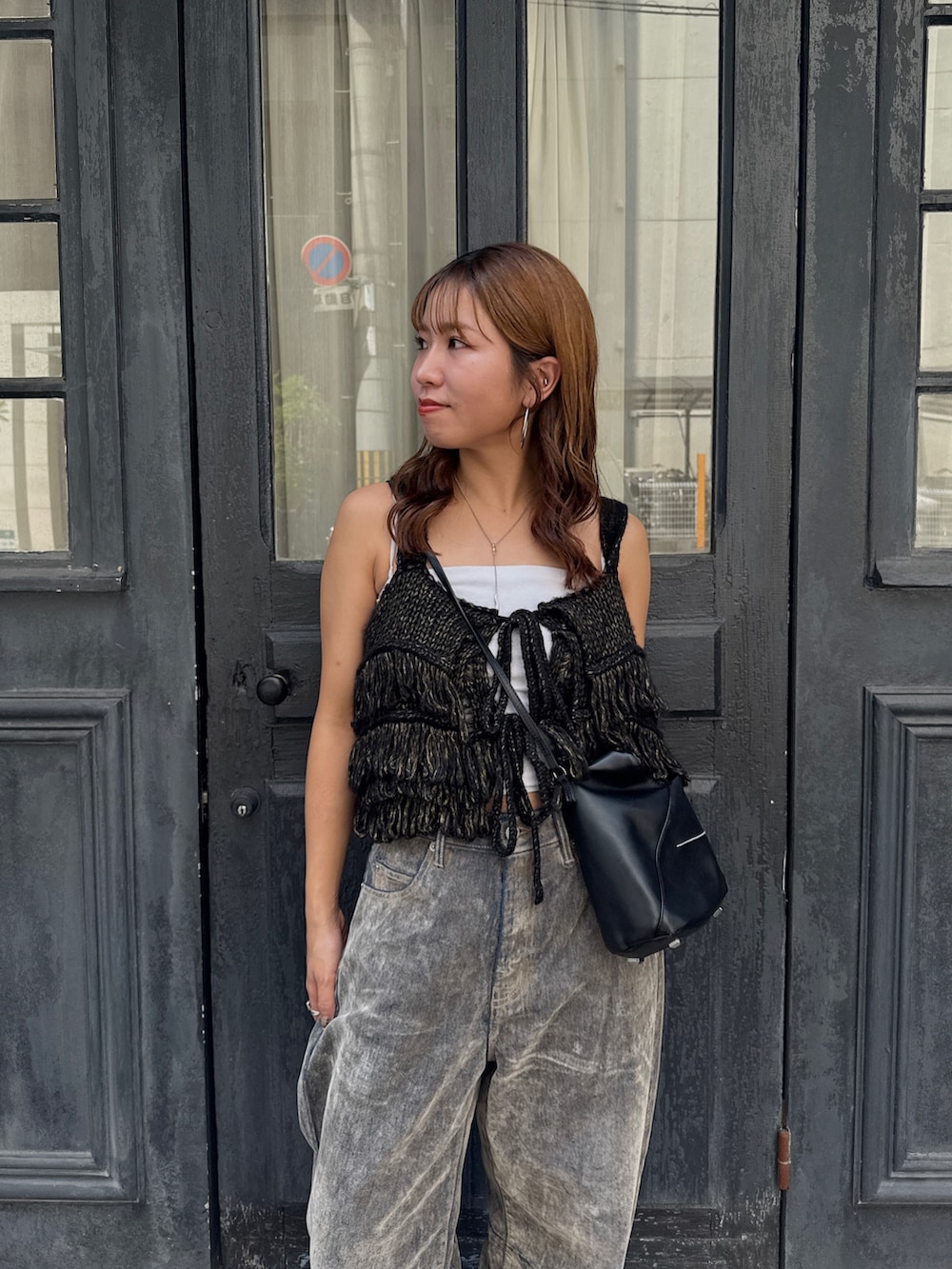 ベージュ系のデニムパンツ、ブラック系のニット/セーター、ベージュ系のスリッポンを着用したレディースの秋コーディネートの8枚目の写真