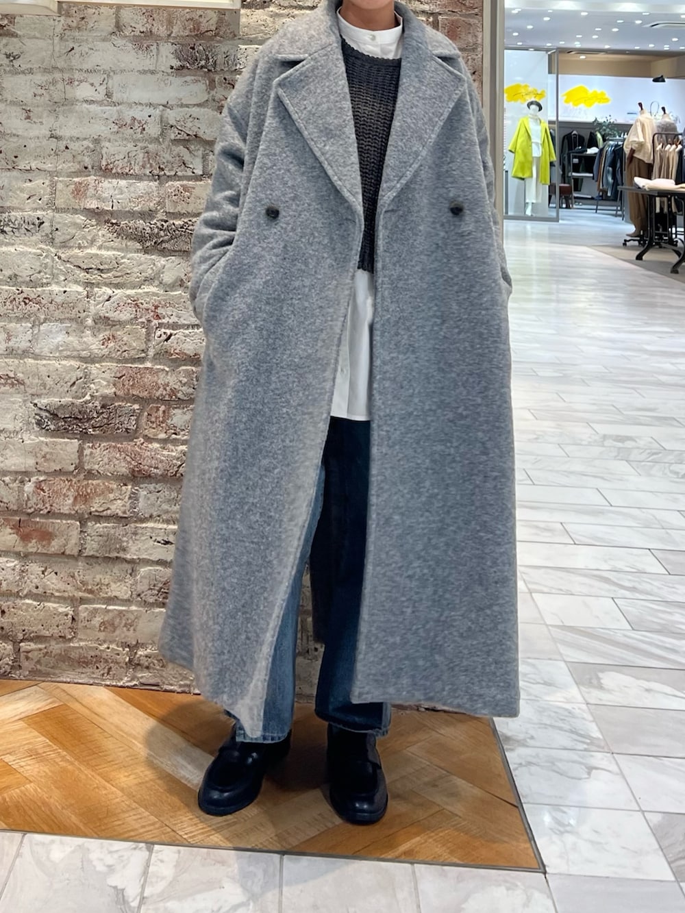 グレー系のニット/セーター、ブルー系のデニムパンツ、ブラック系のローファーを着用したレディースの秋コーディネートの5枚目の写真