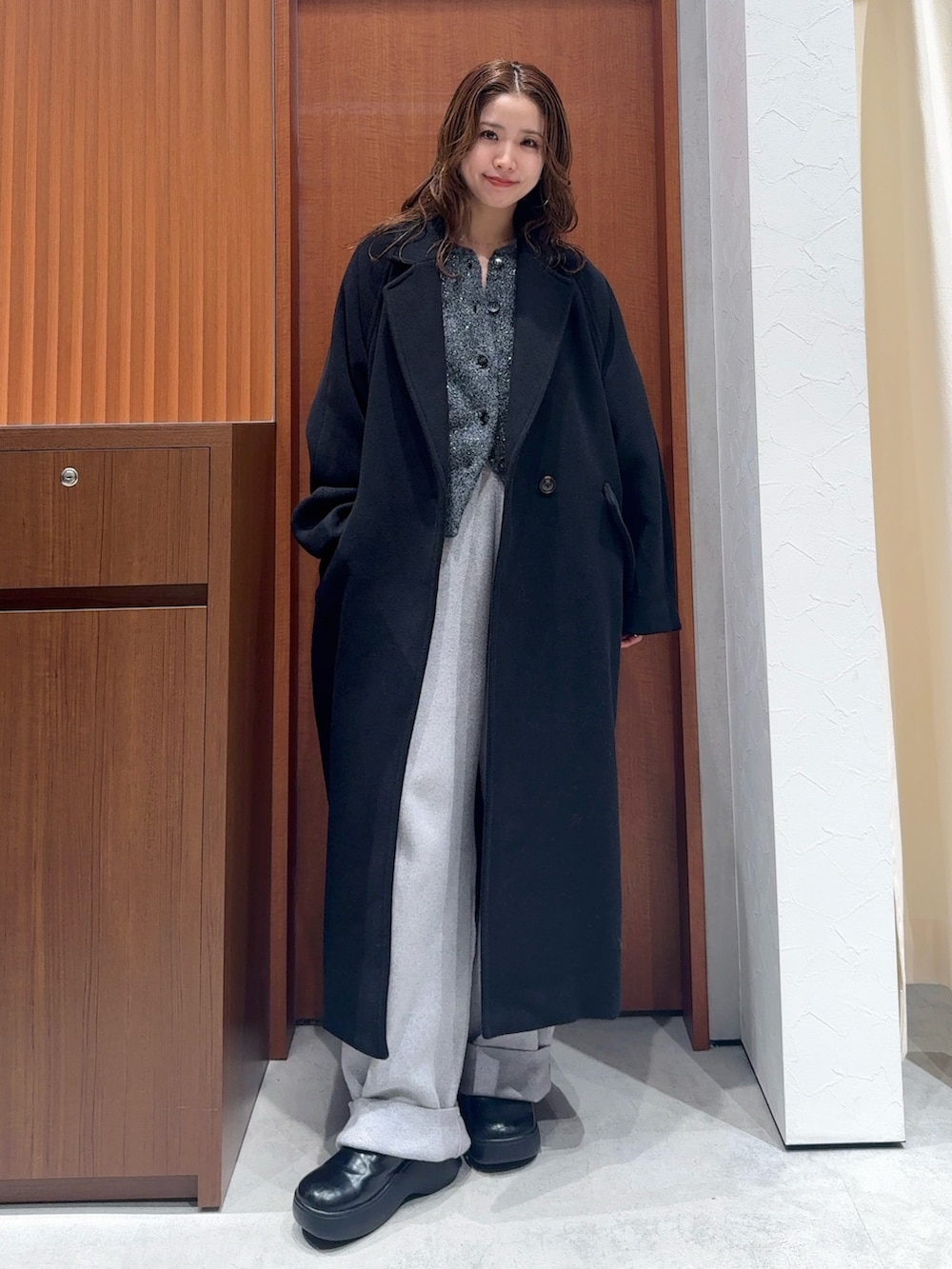 グレー系のカーディガン/ボレロ、グレー系のその他パンツ、ブラック系のチェスターコートを着用したレディースの冬コーディネートの2枚目の写真