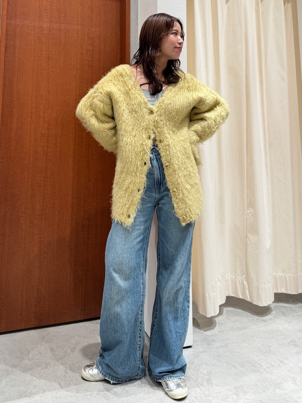 ブルー系のデニムパンツ、イエロー系のカーディガン/ボレロを着用したレディースの秋コーディネートの6枚目の写真