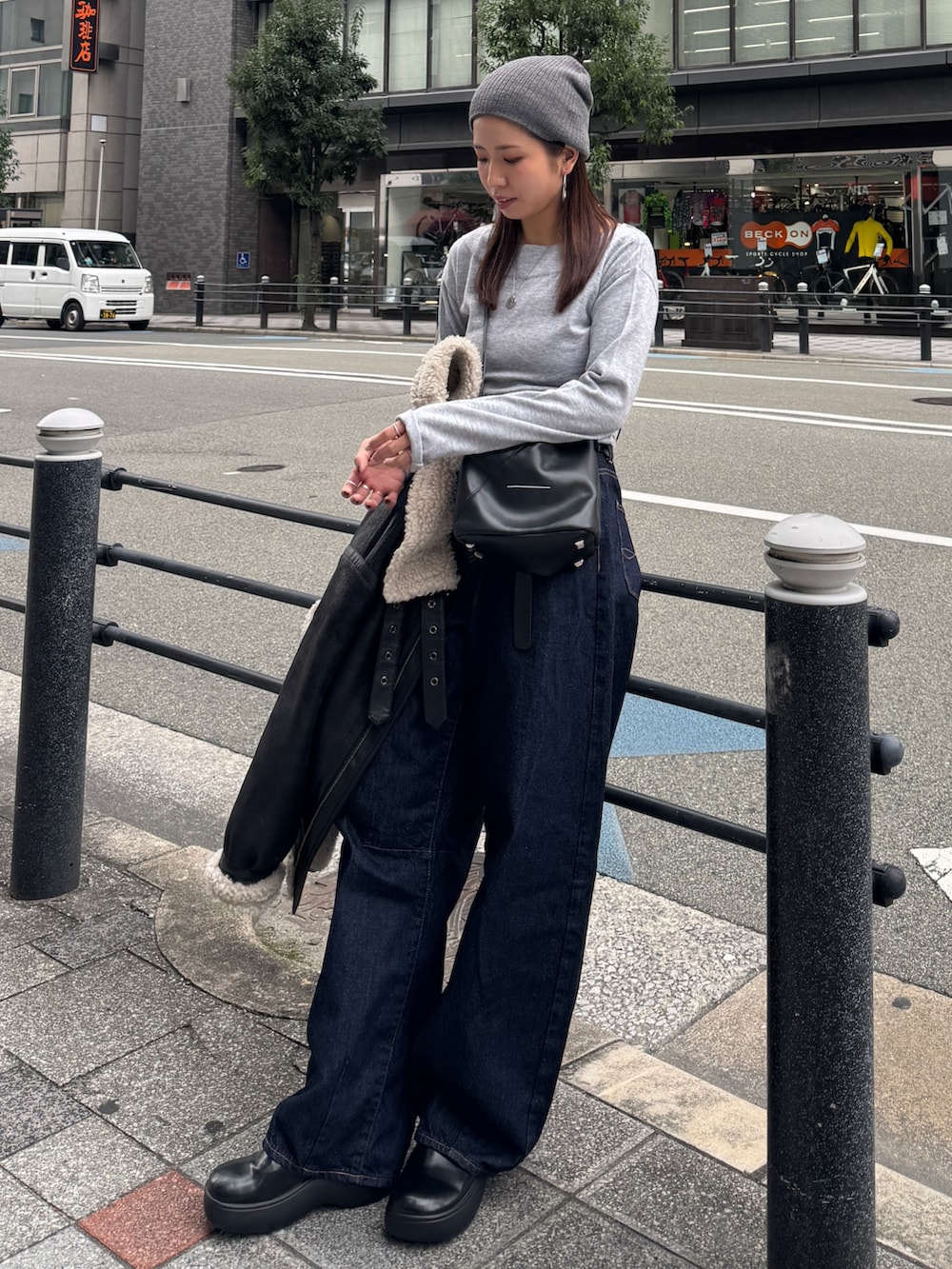 グレー系のニット/セーター、ブルー系のデニムパンツ、グレー系のニットキャップ/ビーニーを着用したレディースの秋コーディネートの2枚目の写真