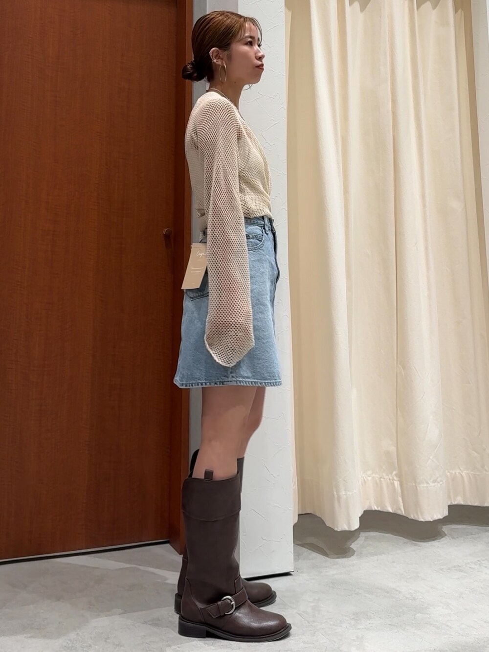 ホワイト系のTシャツ/カットソー、ブルー系のスカート、ブラウン系のブーツを着用したレディースの春コーディネートの5枚目の写真