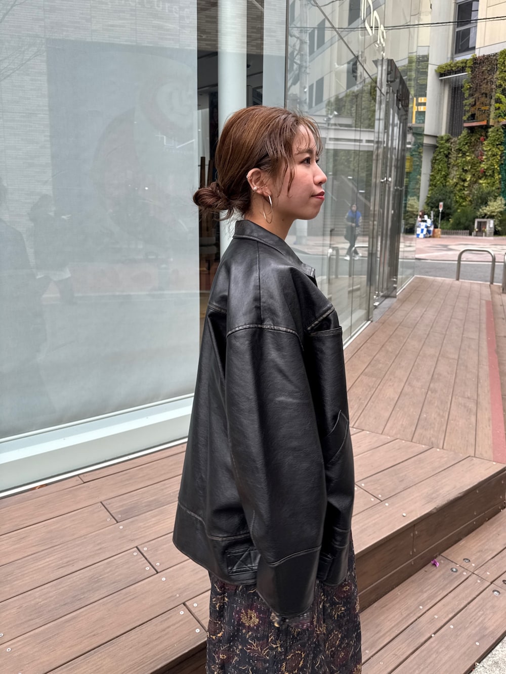 ブラック系のブルゾン、ブラック系のワンピース、ブルー系のデニムパンツを着用したレディースの冬コーディネートの8枚目の写真