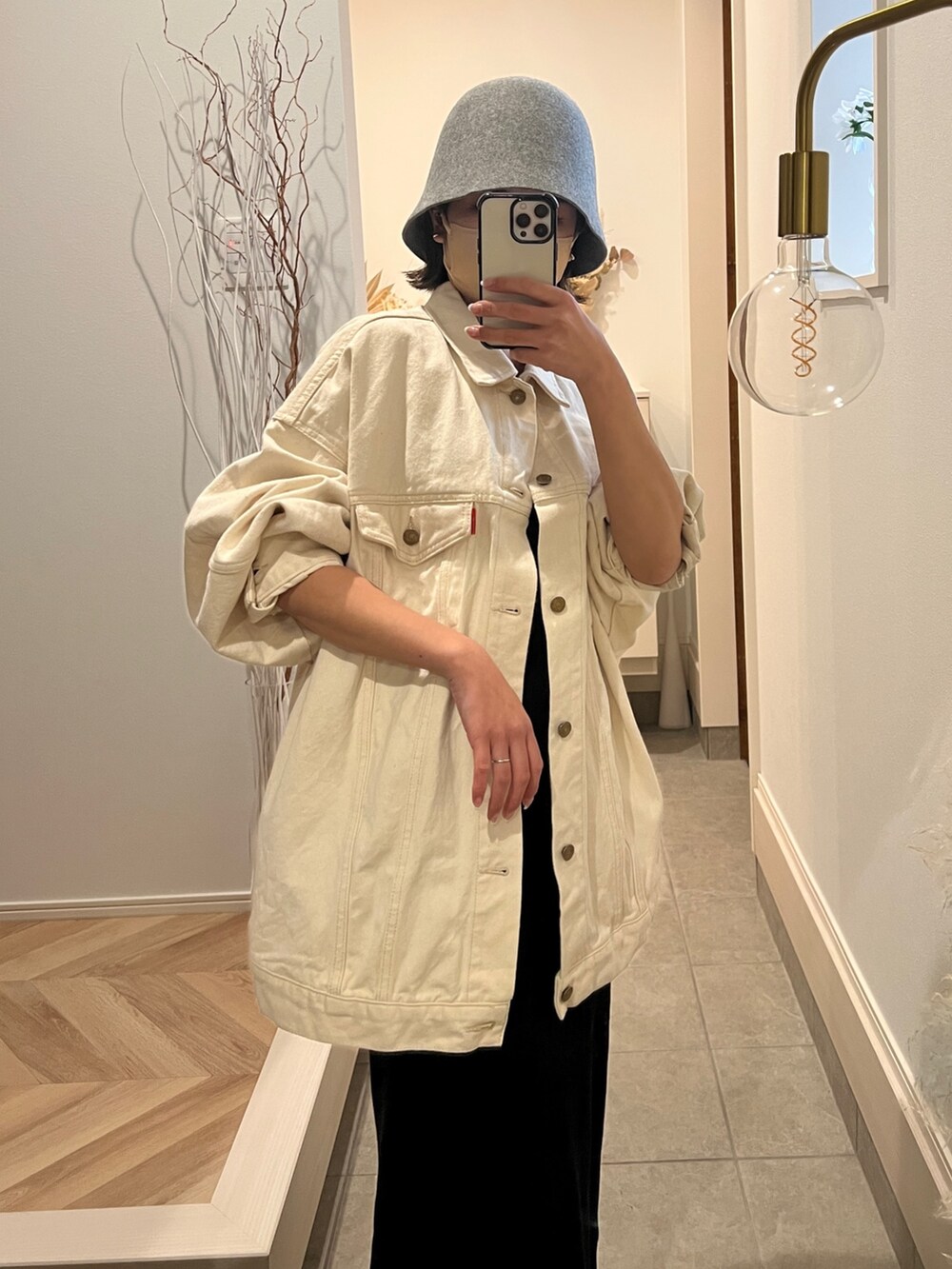 ホワイト系のデニムジャケット、ブラック系のワンピース、グレー系のハットを着用したレディースの冬コーディネートの3枚目の写真