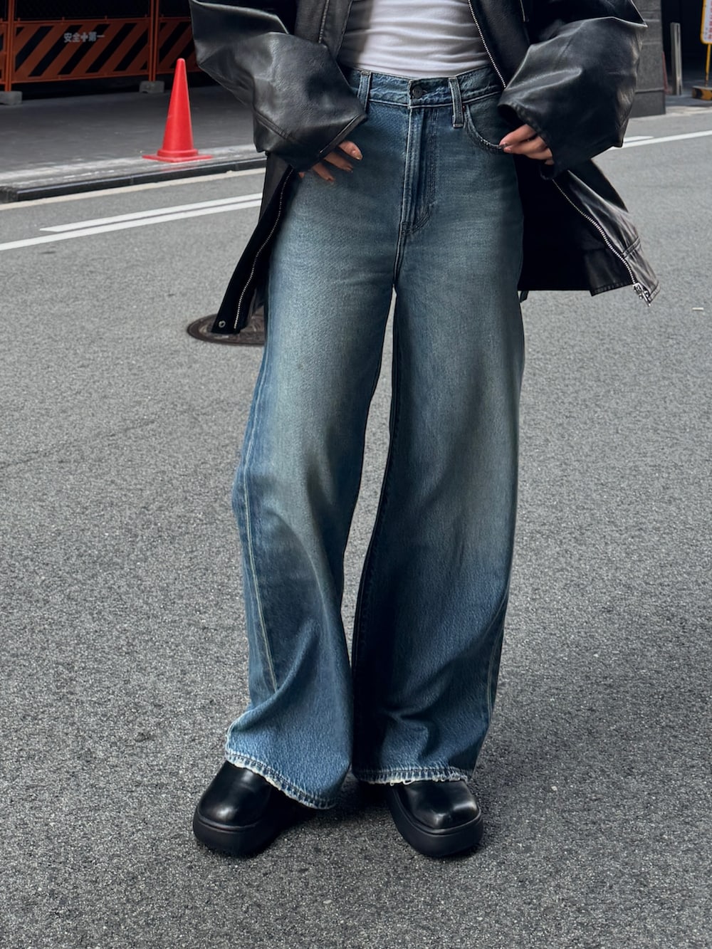 ブラック系のブルゾン、ブルー系のデニムパンツを着用したレディースの秋コーディネートの8枚目の写真