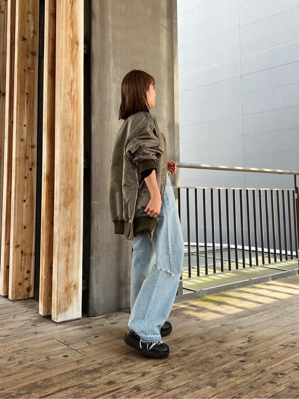 グリーン系のMA-1、ブルー系のデニムパンツ、ブルー系のデニムパンツを着用したレディースの秋コーディネートの5枚目の写真