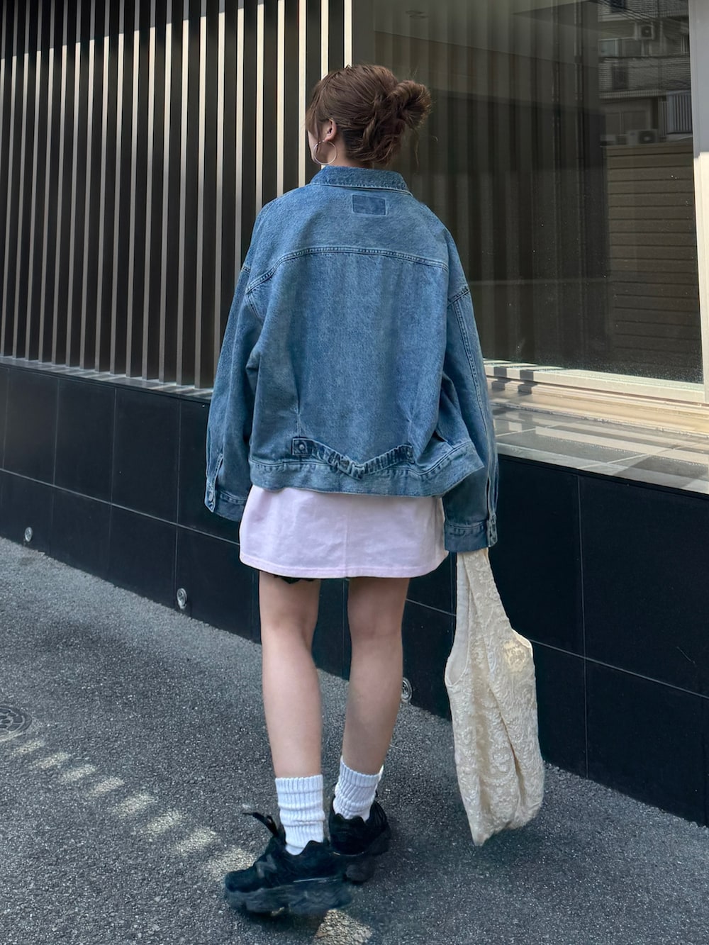 ピンク系のTシャツ/カットソー、ブルー系のデニムジャケット、ブラック系のその他パンツを着用したレディースの春コーディネートの6枚目の写真