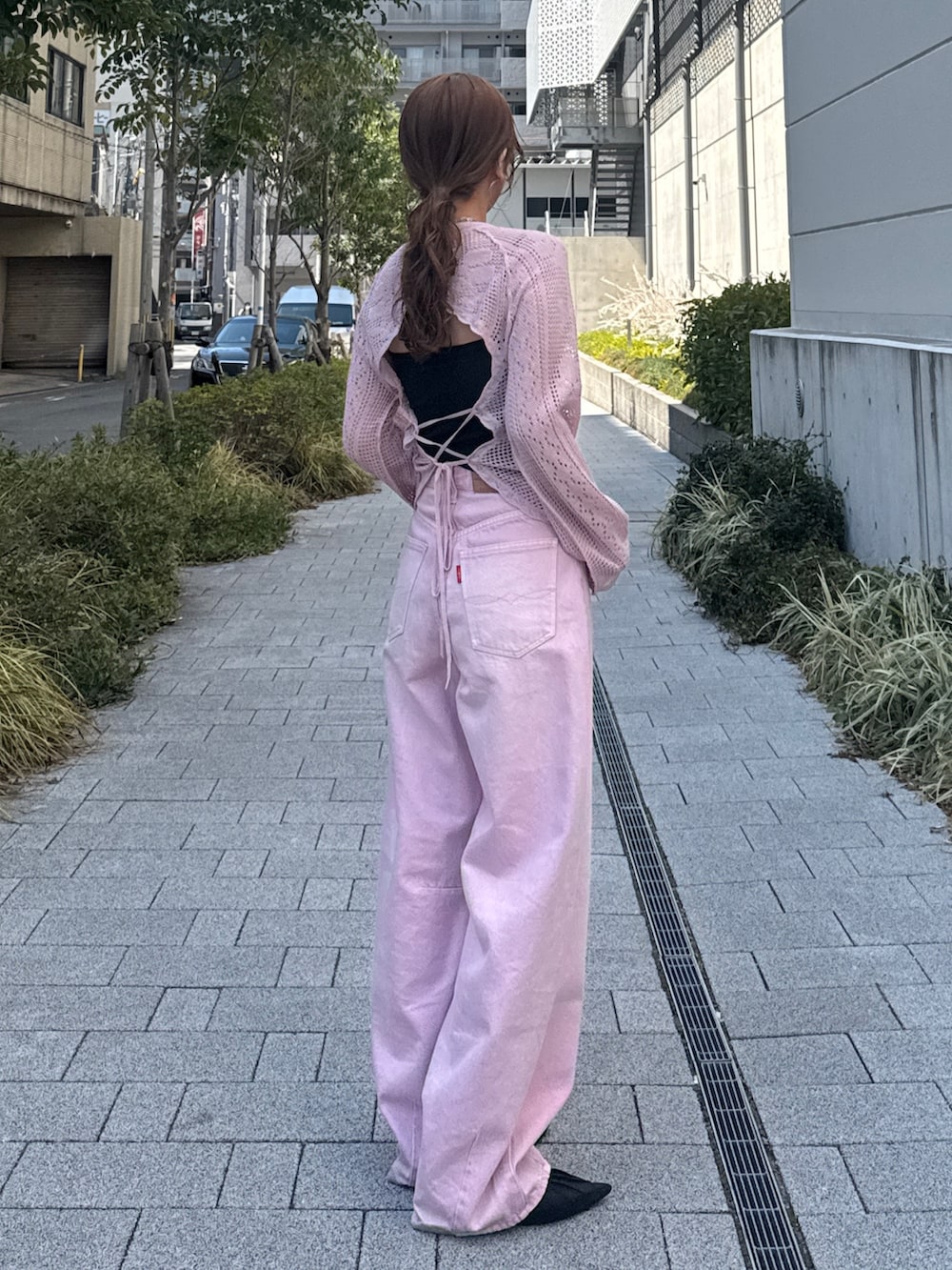 ピンク系のデニムパンツ、ピンク系のニット/セーター、ブラック系のパンプスを着用したレディースの春コーディネートの3枚目の写真