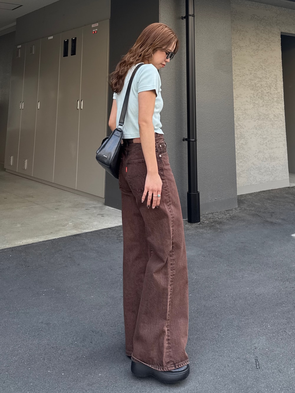 ブラウン系のデニムパンツ、ブルー系のTシャツ/カットソーを着用したレディースの春コーディネートの3枚目の写真