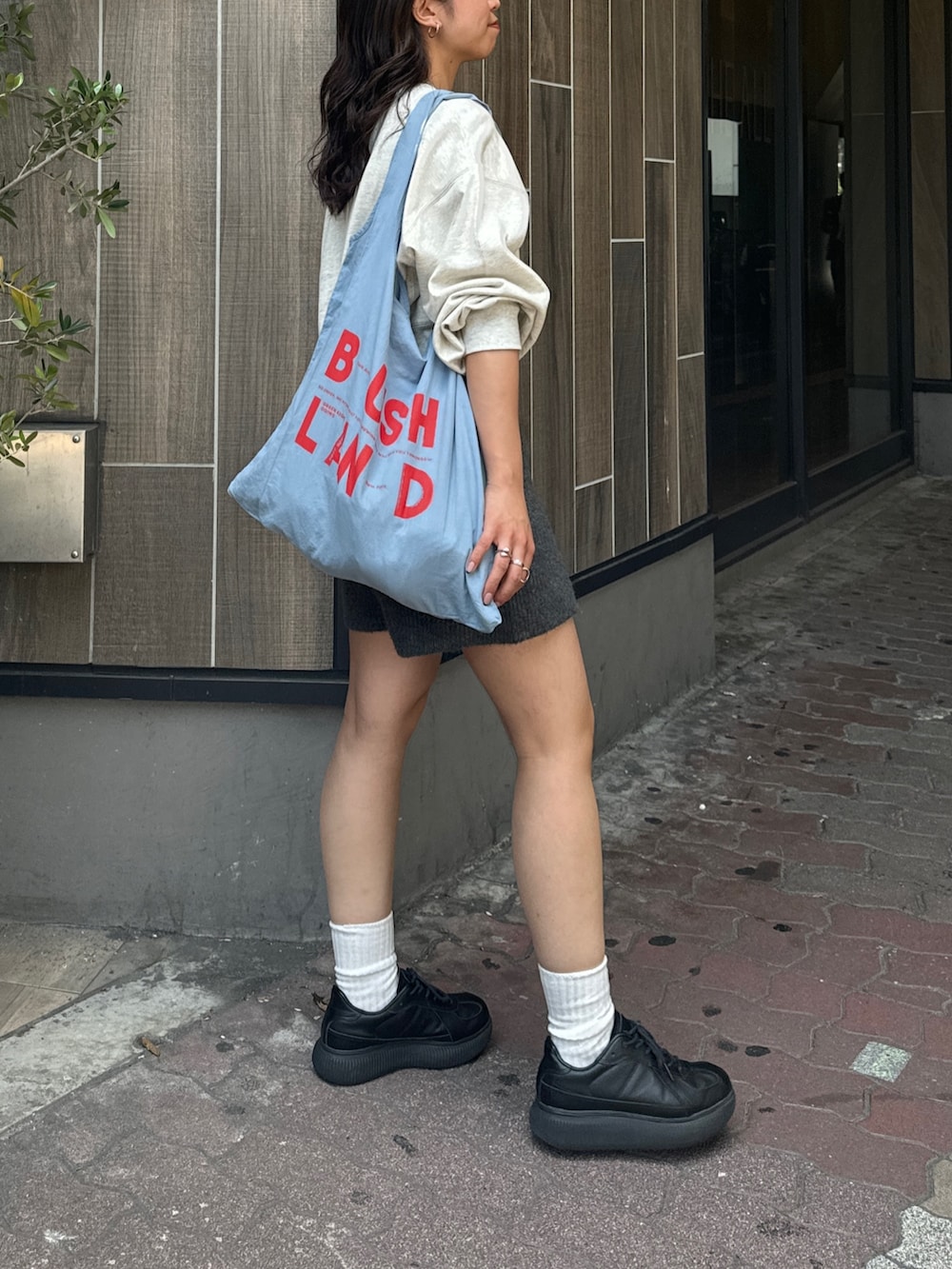 グレー系のその他パンツ、グレー系のスウェット、ブルー系のエコバッグ/サブバッグを着用したレディースの夏コーディネートの3枚目の写真