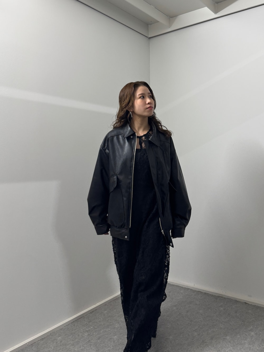 ブラック系のワンピース、ブラック系のブルゾン、ブラック系のブーツを着用したレディースの冬コーディネートの5枚目の写真