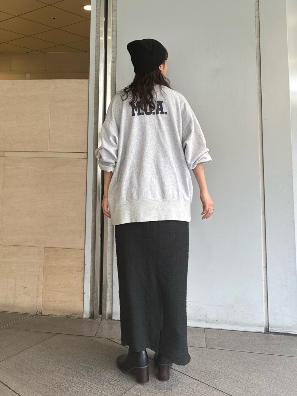 グレー系のスウェット、ブラック系のスカート、ブラック系のニットキャップ/ビーニーを着用したレディースの夏コーディネートの4枚目の写真