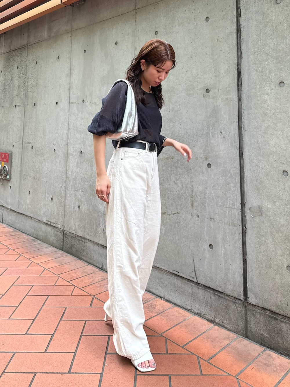 シルバー系のハンドバッグ、ホワイト系のデニムパンツ、グレー系のTシャツ/カットソーを着用したレディースの夏コーディネートの4枚目の写真