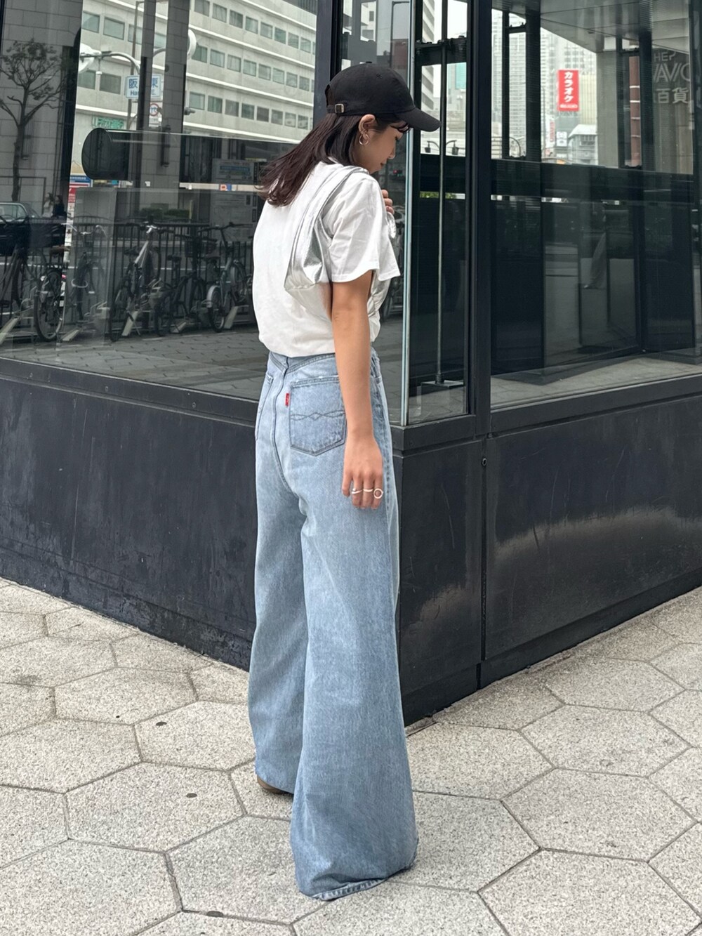ブルー系のデニムパンツ、ホワイト系のTシャツ/カットソー、シルバー系のハンドバッグを着用したレディースの春コーディネートの9枚目の写真