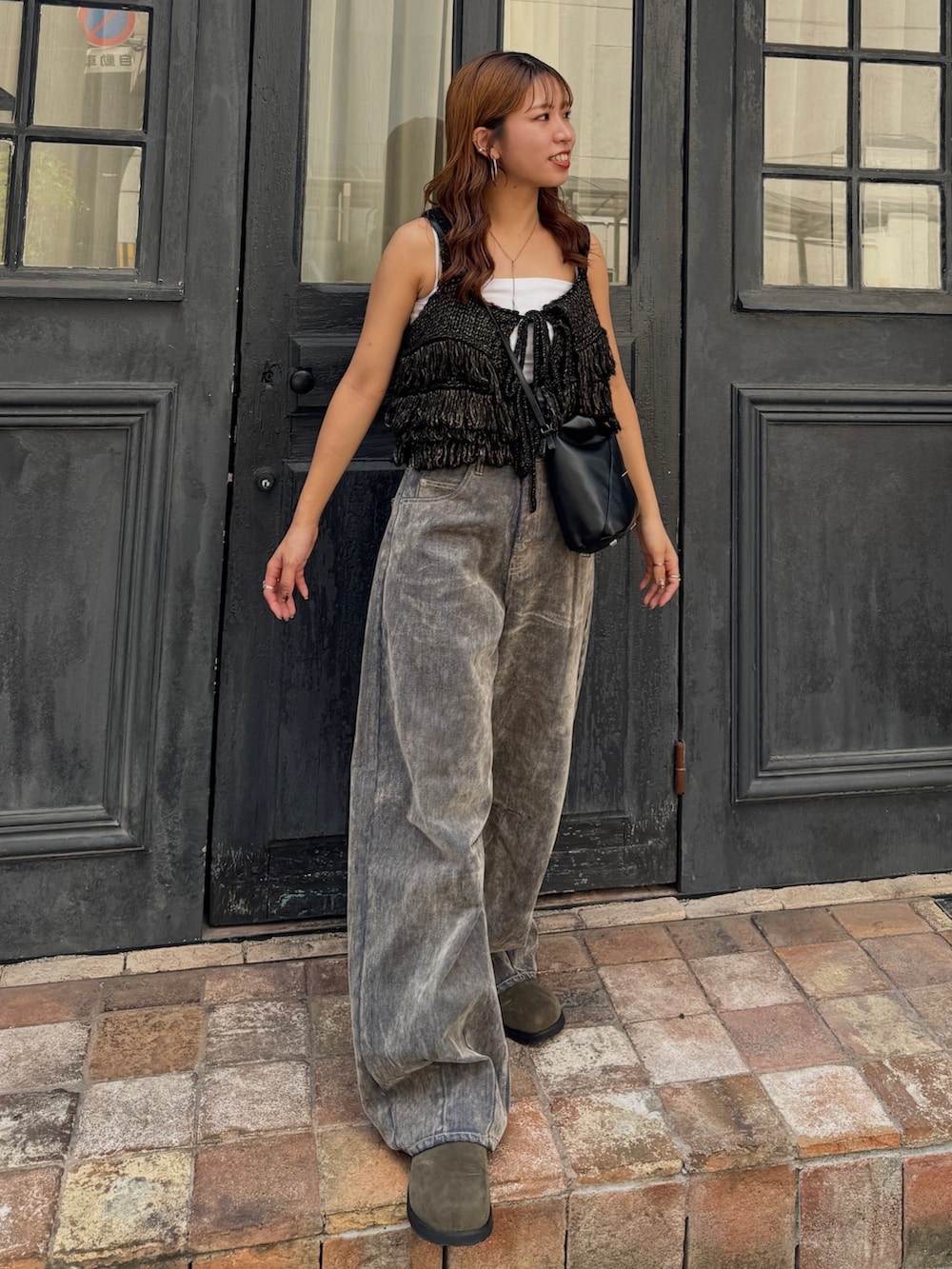 ベージュ系のデニムパンツ、ブラック系のニット/セーター、ベージュ系のスリッポンを着用したレディースの秋コーディネートの7枚目の写真