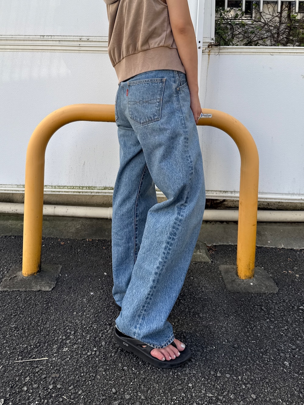 ベージュ系のパーカー、ブルー系のデニムパンツを着用したレディースの夏コーディネートの9枚目の写真