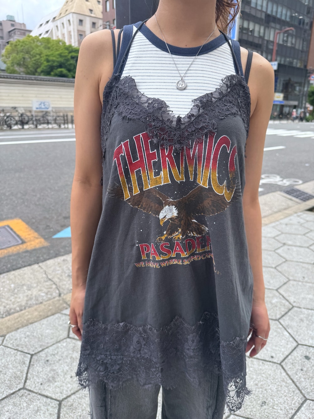 グレー系のキャミソール、ホワイト系のタンクトップ、ブラック系のデニムパンツを着用したレディースの夏コーディネートの6枚目の写真