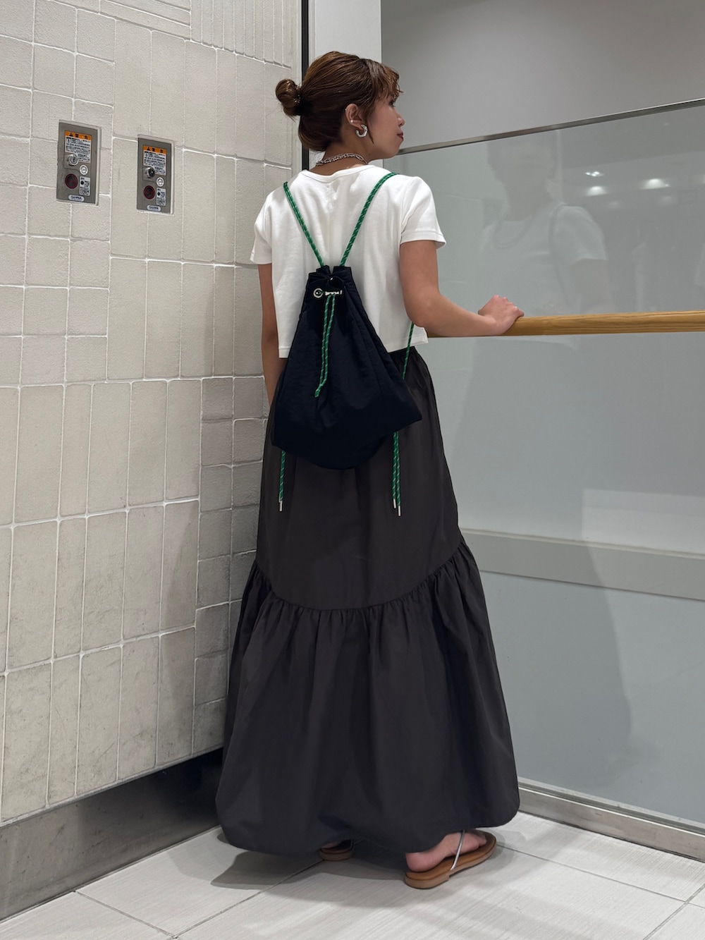 グレー系のスカート、シルバー系のサンダル、ホワイト系のTシャツ/カットソーを着用したレディースの春コーディネートの7枚目の写真