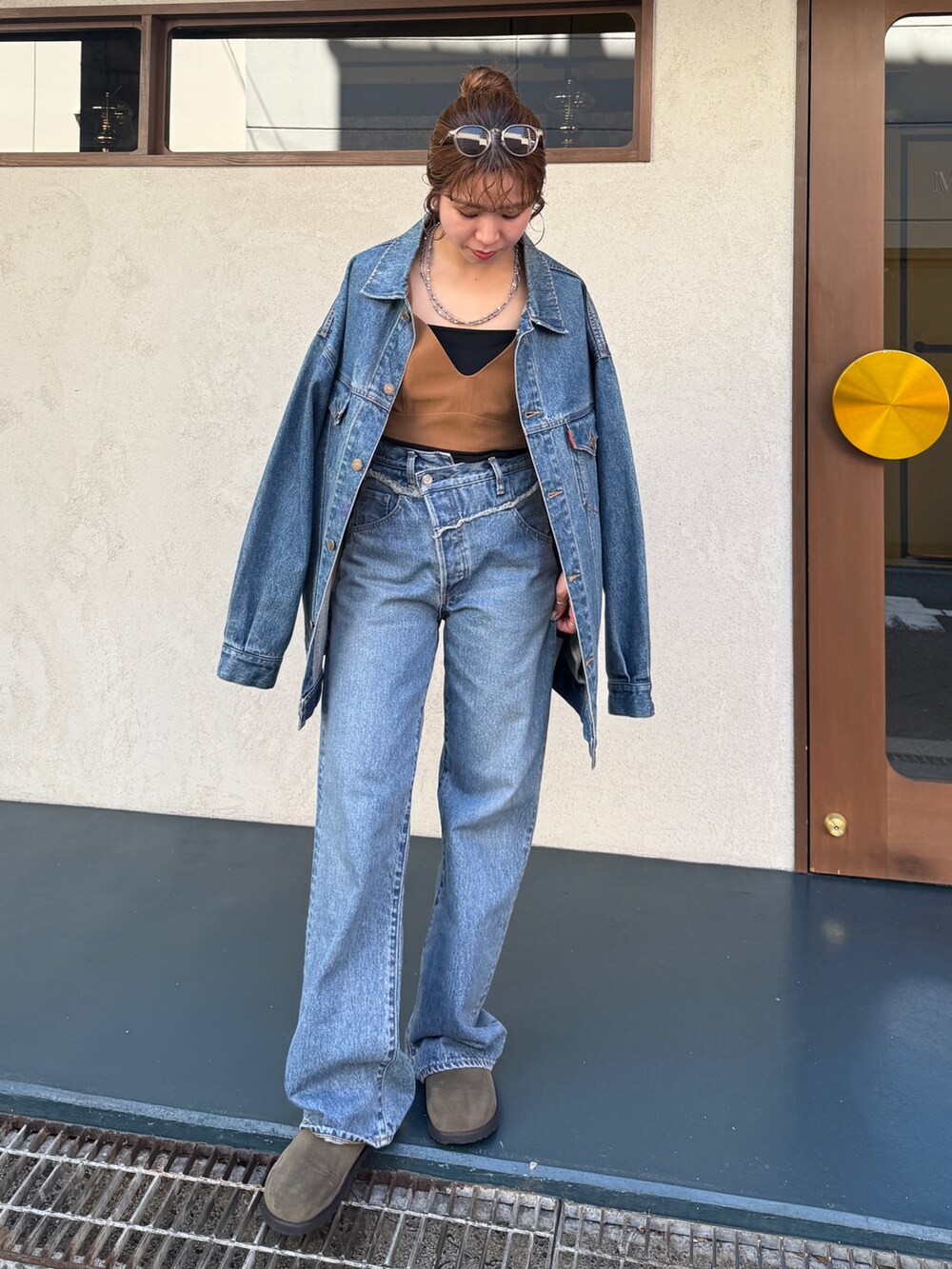 ブルー系のデニムパンツ、ベージュ系のスリッポン、ブラウン系のキャミソールを着用したレディースの夏コーディネートの2枚目の写真