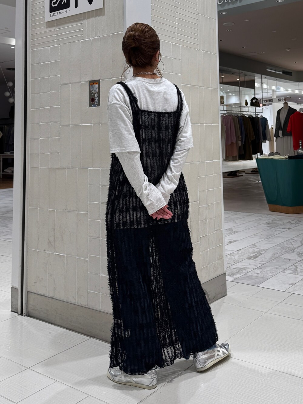 ブラック系のワンピース、グレー系のTシャツ/カットソー、ブルー系のデニムパンツを着用したレディースの春コーディネートの6枚目の写真