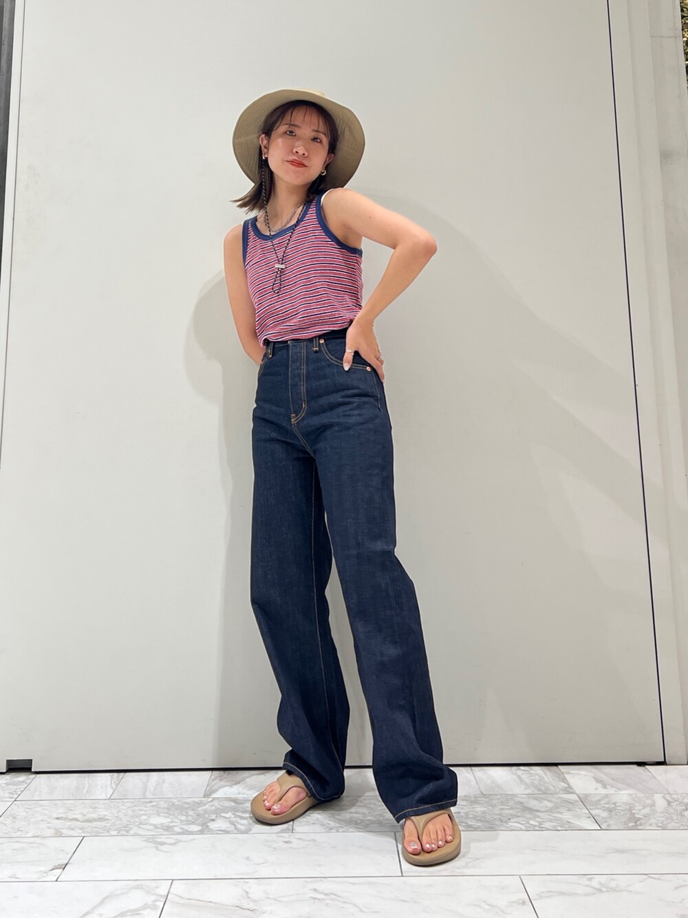 ブルー系のデニムパンツ、ブルー系のタンクトップ、ホワイト系のキャミソールを着用したレディースの夏コーディネートの9枚目の写真