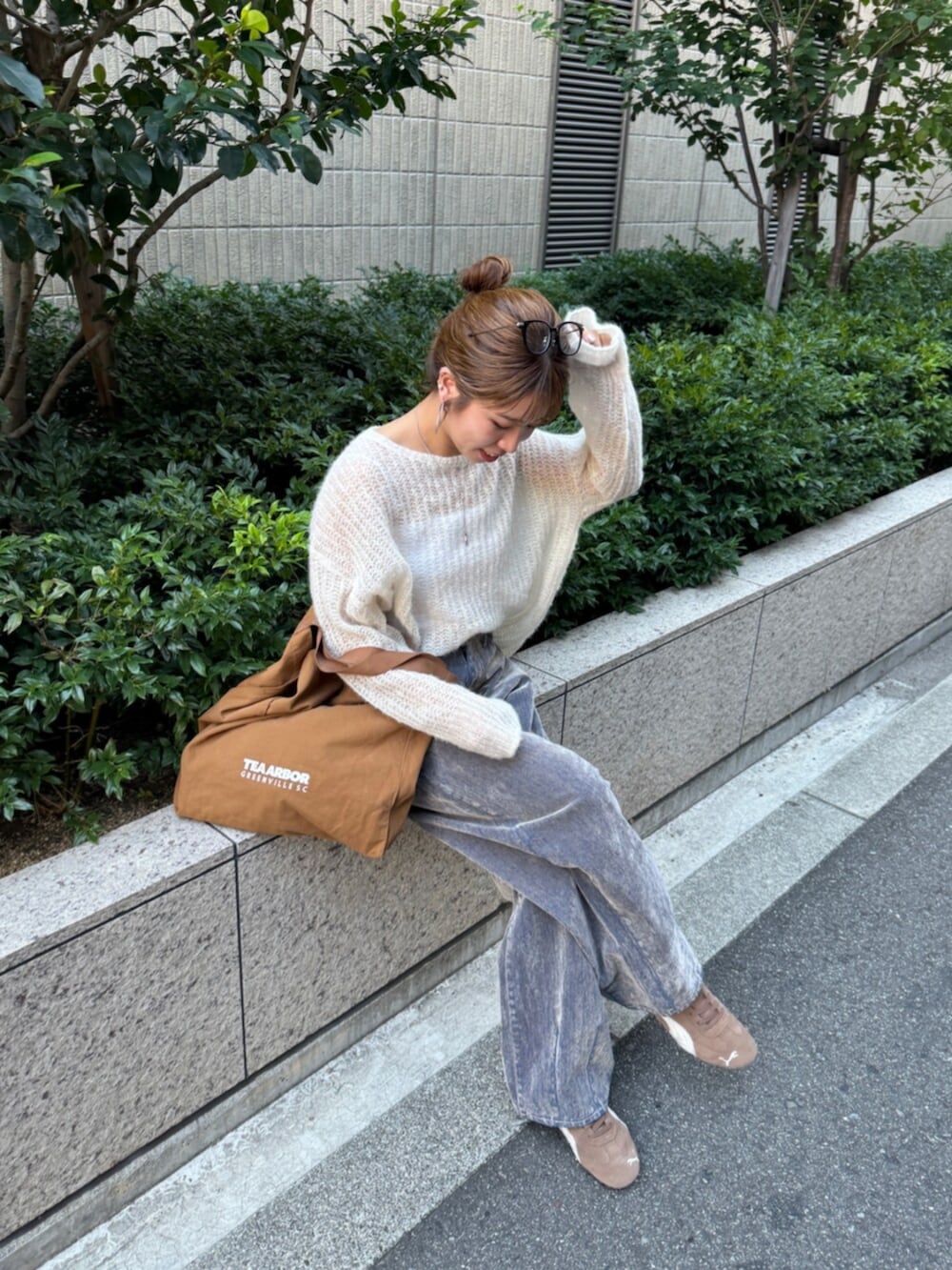 ベージュ系のデニムパンツ、ホワイト系のニット/セーター、ブラウン系のトートバッグを着用したレディースの夏コーディネートの6枚目の写真