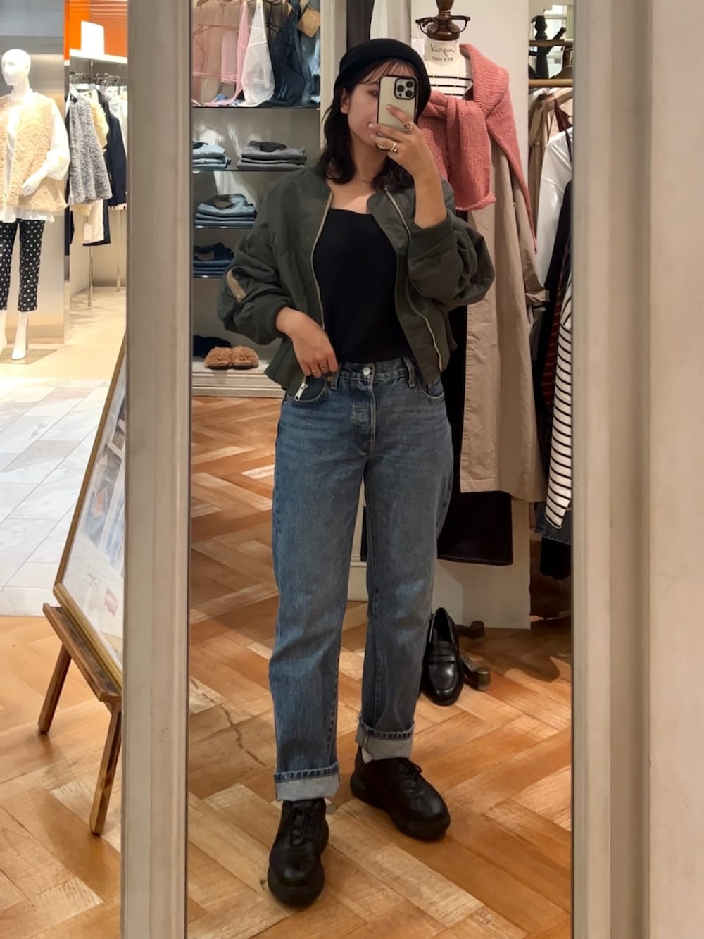 ブラック系のキャミソール、ブルー系のデニムパンツ、グリーン系のブルゾンを着用したレディースの秋コーディネートの5枚目の写真