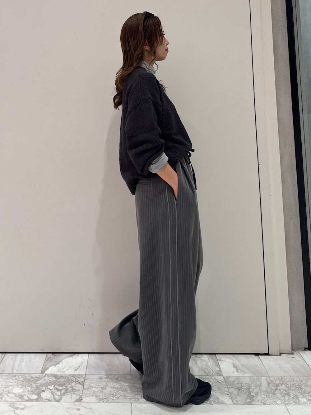 グレー系のその他パンツ、グレー系のニット/セーター、ブルー系のTシャツ/カットソーを着用したレディースの冬コーディネートの4枚目の写真