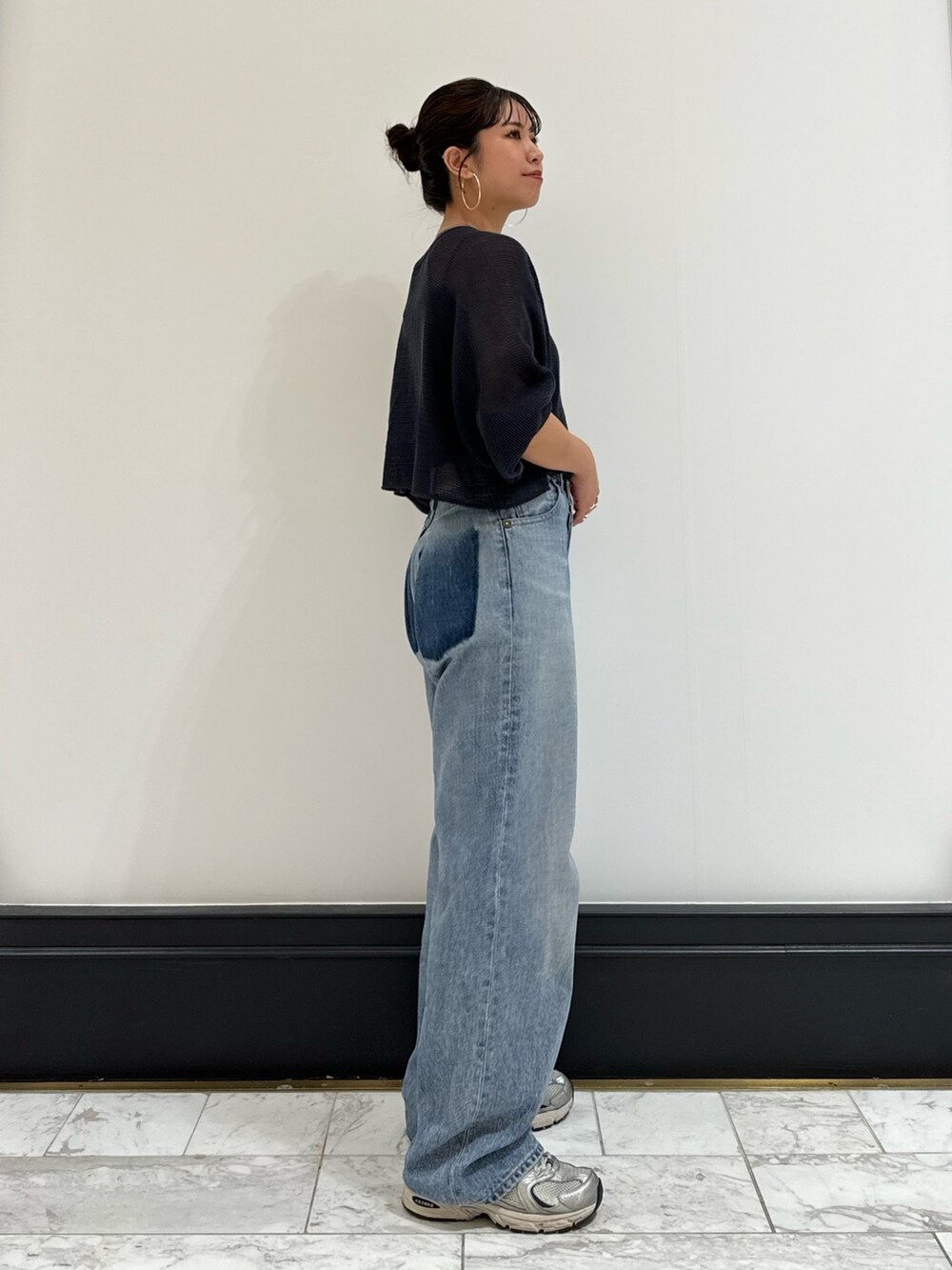 ブラック系のキャミソール、グレー系のTシャツ/カットソー、ブルー系のデニムパンツを着用したレディースの春コーディネートの4枚目の写真