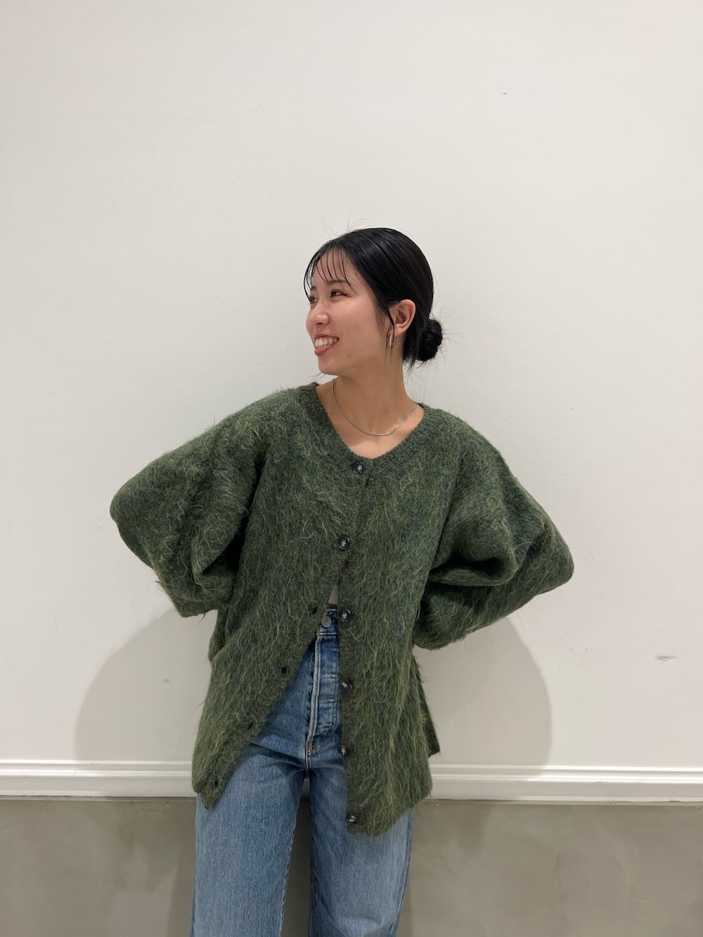 ブルー系のデニムパンツ、グリーン系のカーディガン/ボレロを着用したレディースの秋コーディネートの7枚目の写真