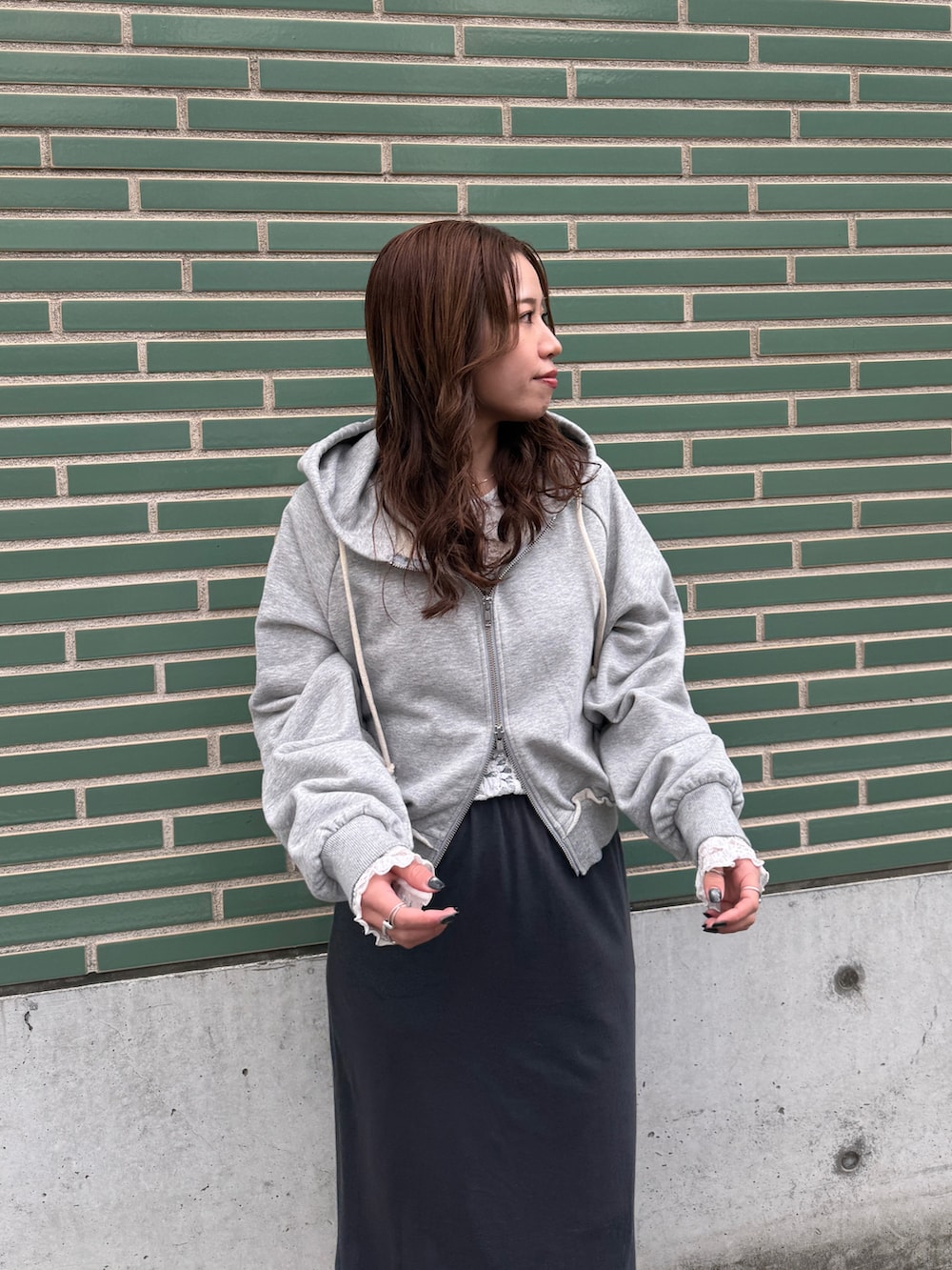 グレー系のパーカー、ホワイト系のTシャツ/カットソー、グレー系のスカートを着用したレディースの冬コーディネートの7枚目の写真