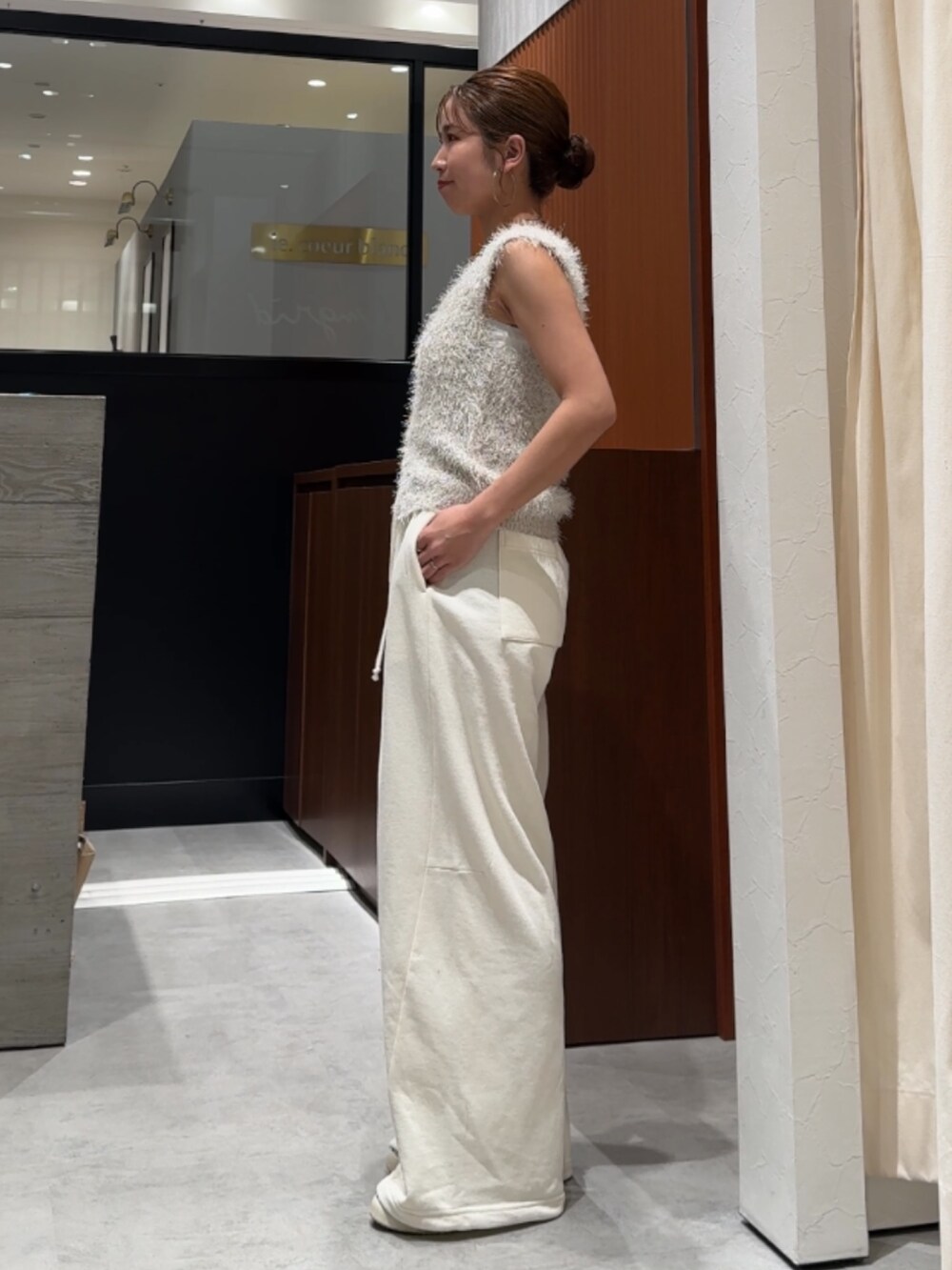 ホワイト系のスウェットパンツ、ホワイト系のベストを着用したレディースの春コーディネートの3枚目の写真