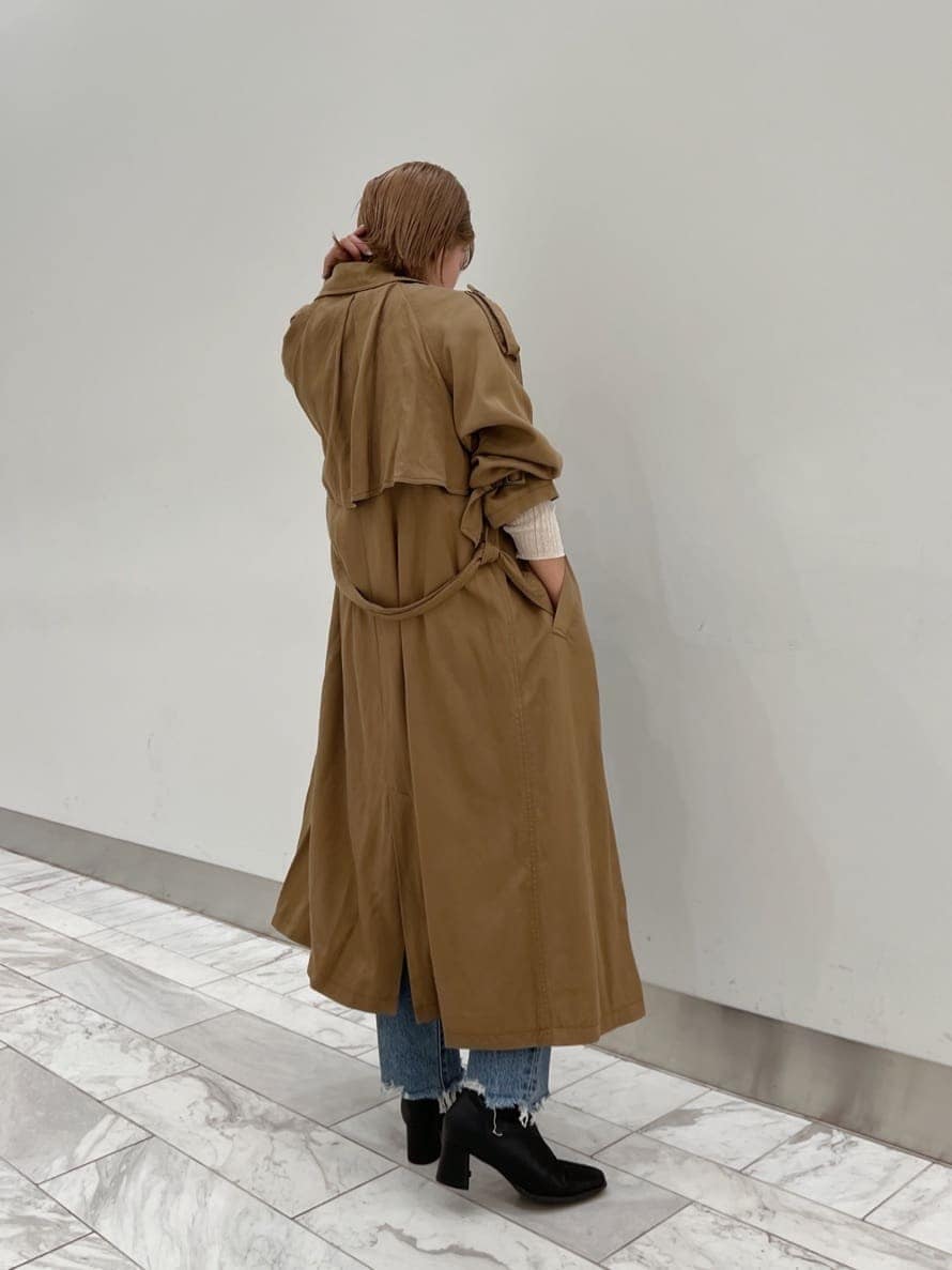 ブラウン系のトレンチコート、ブラック系のブーツ、ホワイト系のニット/セーターを着用したレディースの夏コーディネートの4枚目の写真