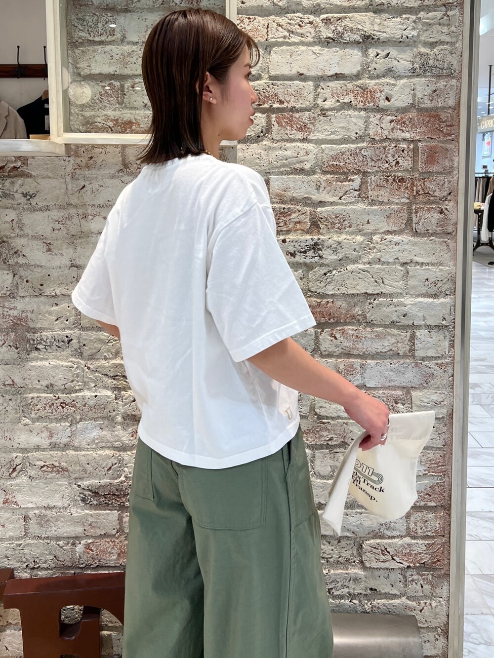 ベージュ系のその他パンツ、ブラック系のサンダル、イエロー系のネックレスを着用したレディースの春コーディネートの8枚目の写真