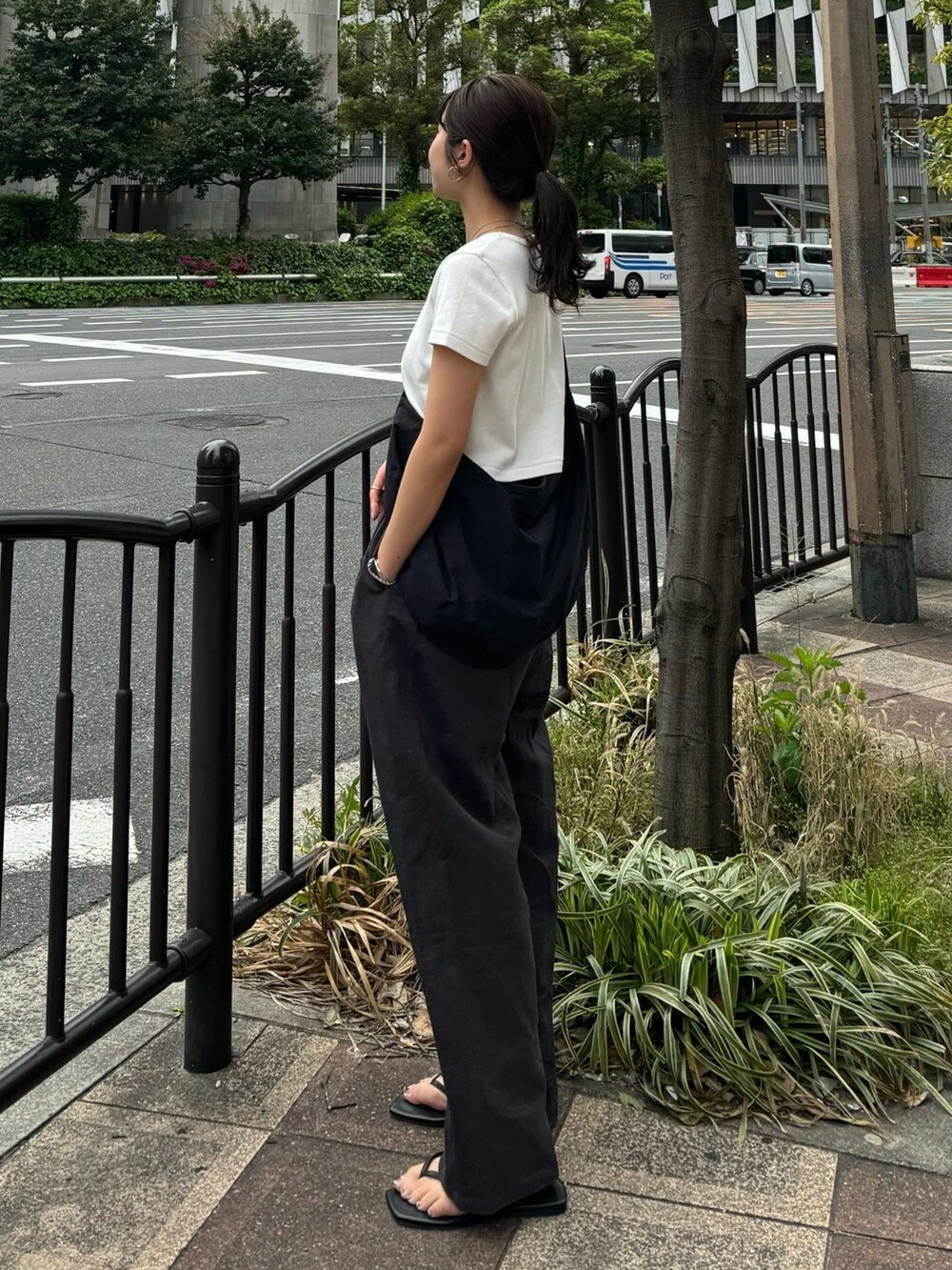 ホワイト系のTシャツ/カットソー、グレー系のその他パンツ、ブラック系のサンダルを着用したレディースの春コーディネートの2枚目の写真